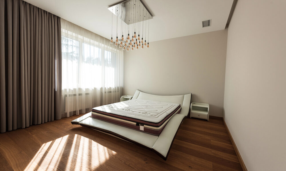 Interieur van moderne slaapkamer met bed en lampen op plafond