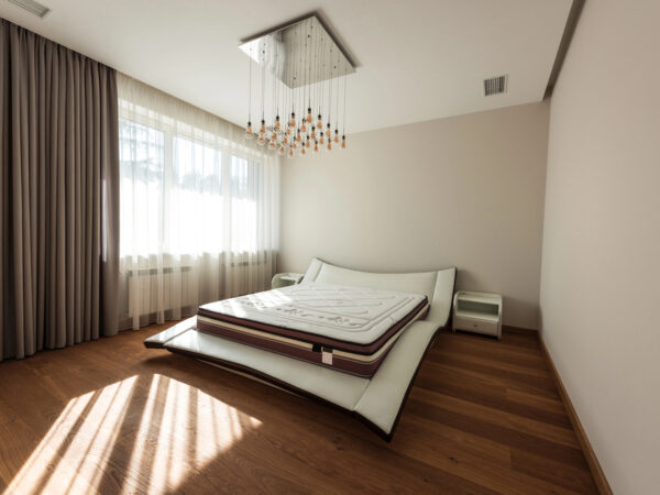 Interieur van moderne slaapkamer met bed en lampen op plafond